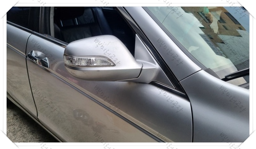 빽미러공장 작업대 위 분해된 어코드 사이드미러(왼쪽)와 고강도 교체 부품(오른쪽) 비교