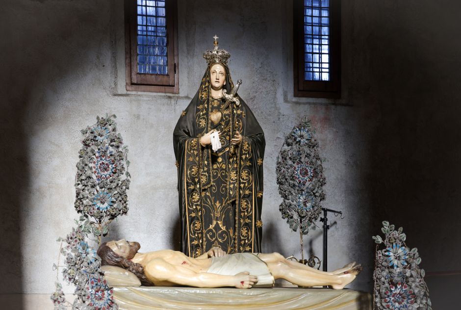 A detailed statue of Virgin Mary with Jesus in a dimly lit cathedral interior.