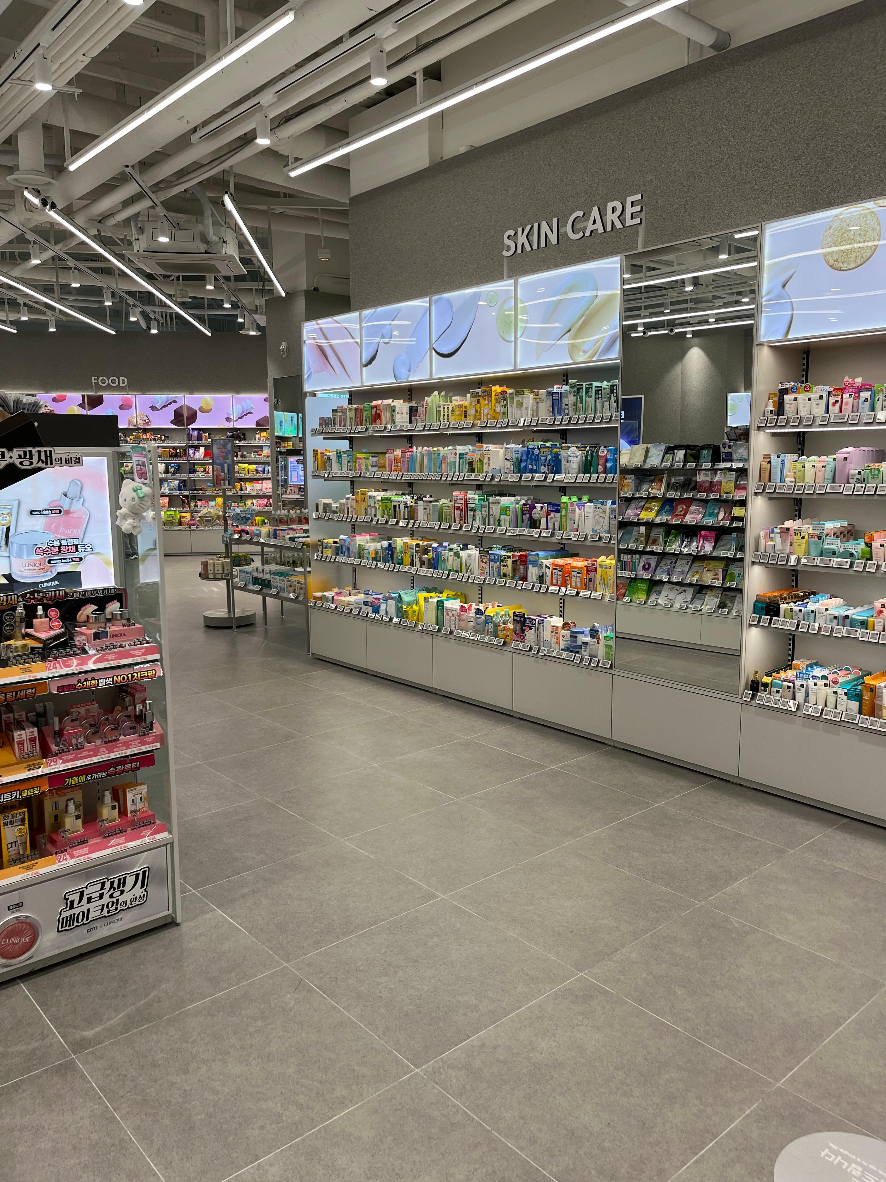 Modern Korean skincare store interior with neatly arranged shelves of toners, lotions, and sheet masks under a glowing &ldquo;SKIN CARE&rdquo; sign. The clean minimalist design reflects Korea&rsquo;s focus on hydration, layering, and gentle beauty routines&mdash;key elements behind the global &ldquo;glass skin&rdquo; and &ldquo;chok-chok&rdquo; trends.