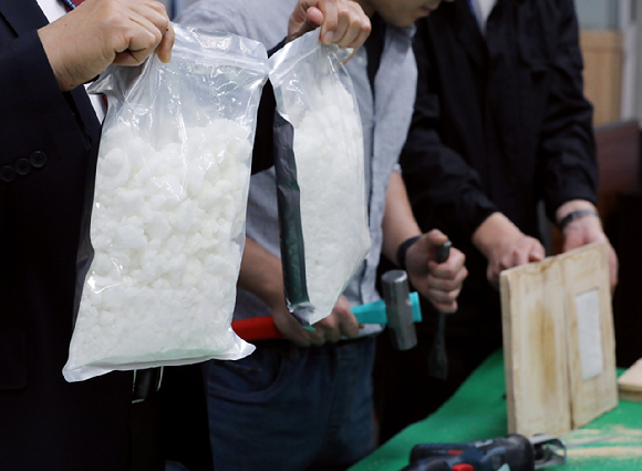 경찰이 10일 오전 서울영등포경찰서에서 열린 필로폰 밀반입 및 유통 말레이시아 조직 검거 관련 브리핑에서 마약 수거 시연을 하고 있다. [사진=뉴시스]