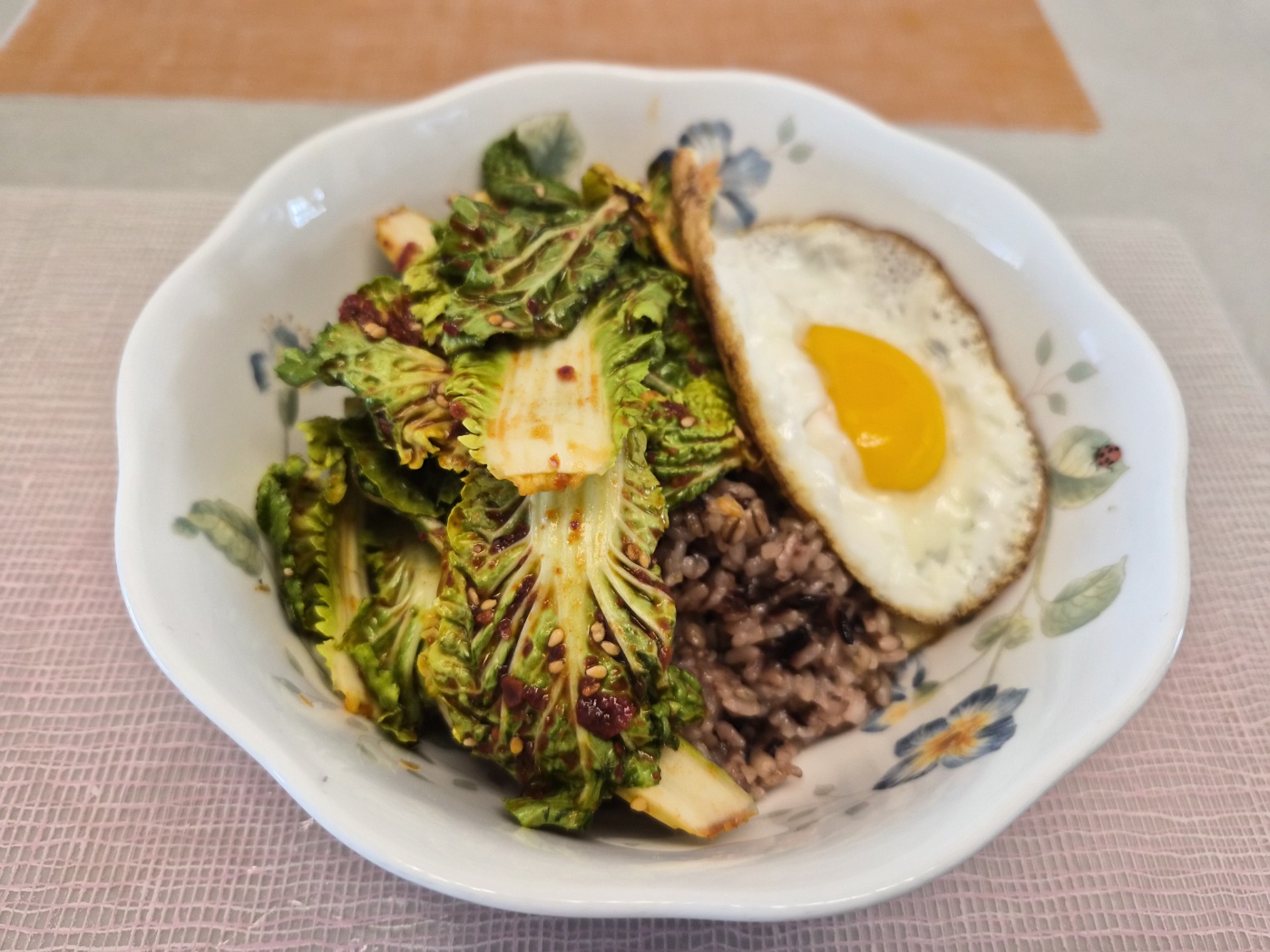 아삭하게 무친 봄동 겉절이와 노란 노른자가 살아있는 달걀 프라이를 곁들인 건강한 봄동 비빔밥