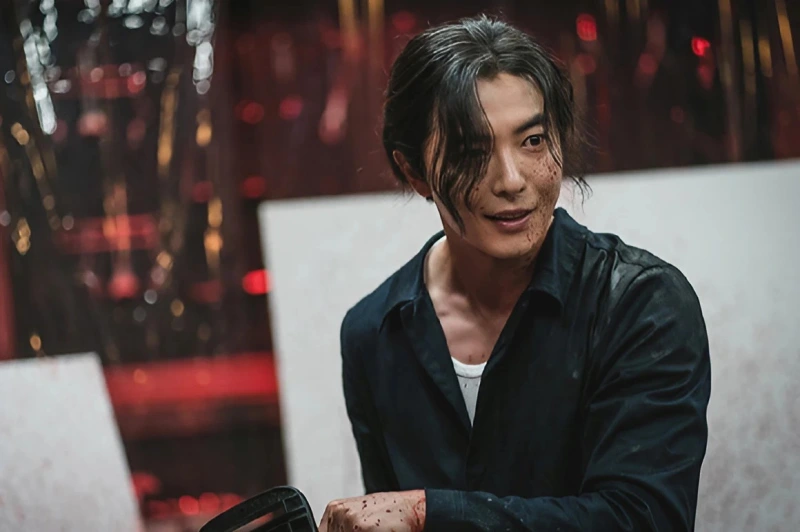 김머리에 검은 와이셔츠를 하고 전기톱을 들고 있는 김재옥