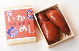 약간 붉은색의 오징어 2마리가 도시락안에 들어가 있다.