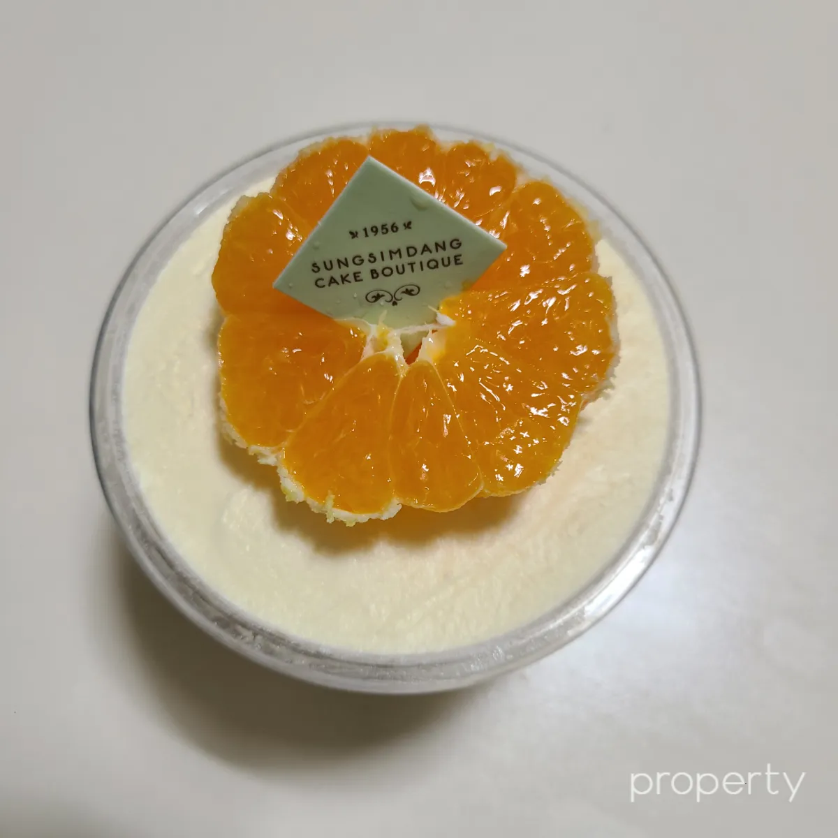 작은컵에-노란빛이도는크림이가득차있고-그위에반자를귤이올려져있는-떠귤