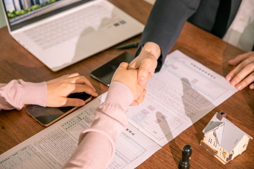 전세계약을 하는 상황(계약서 작성 및 도장날인후 서로 악수하는 모습)을 연출한 화면캡쳐 사진