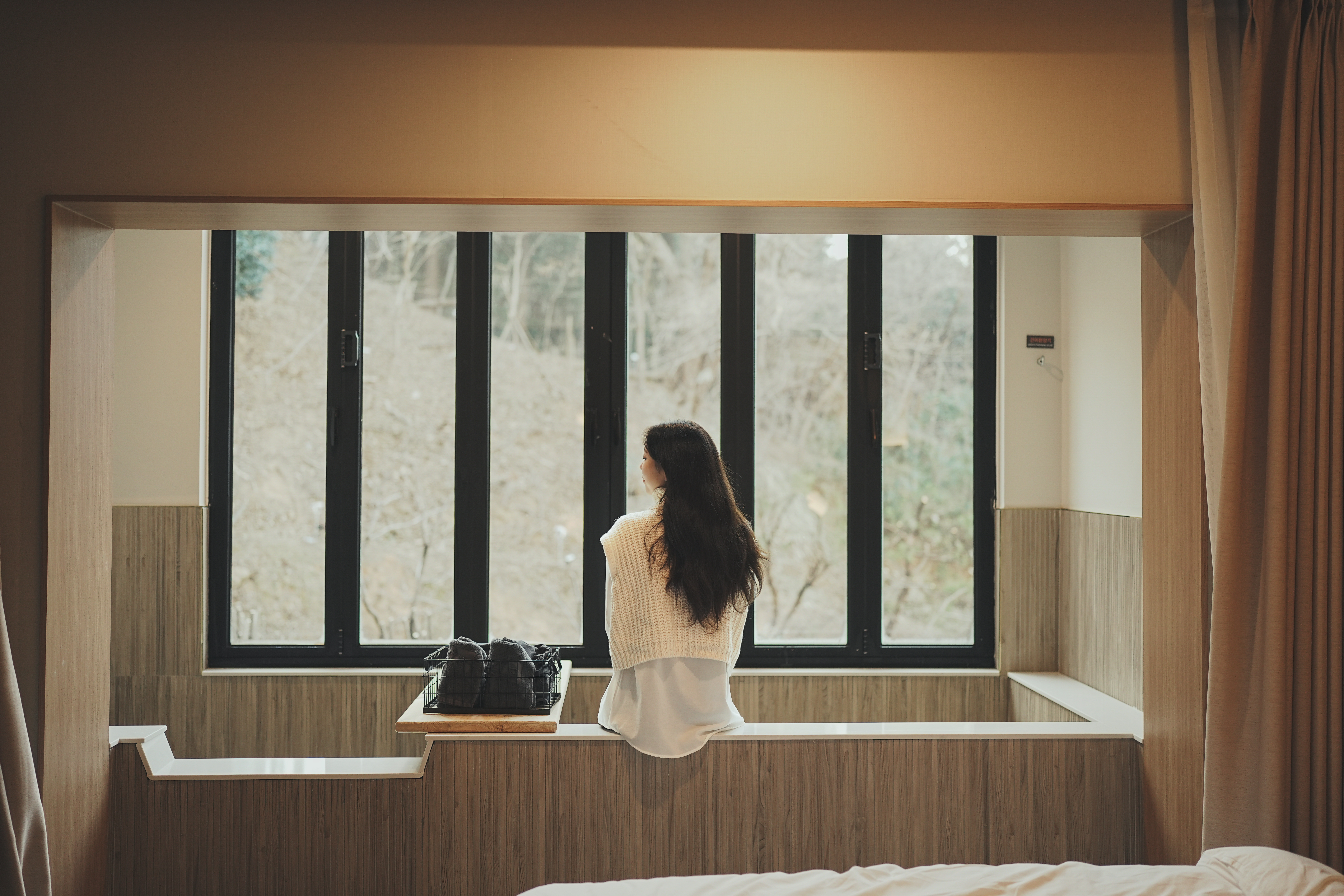 햇살이 들어오는 창가에 앉아있는 인물