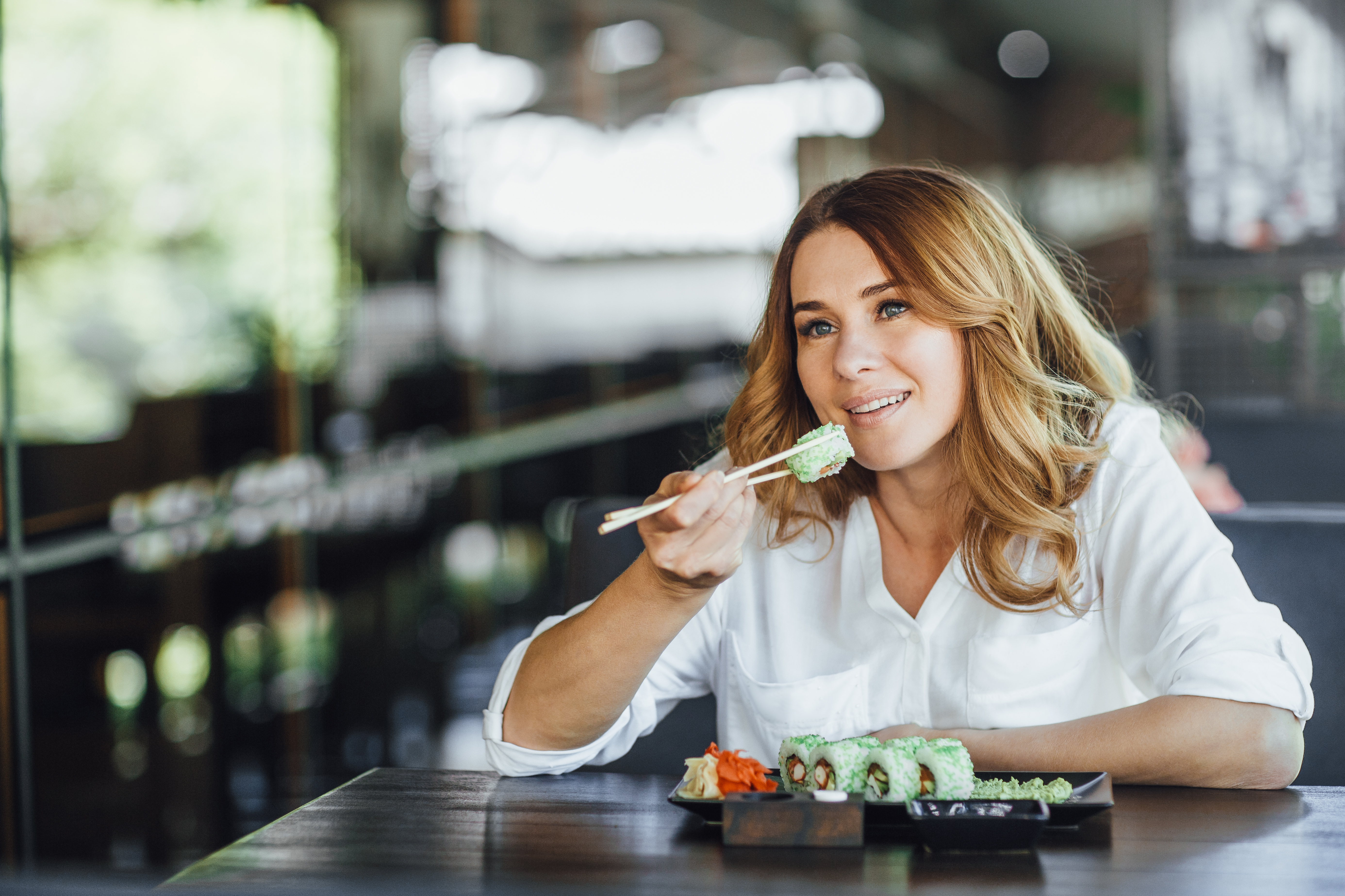 레스토랑에서 초밥을 즐기는 중년 여성의 미소｜균형 잡힌 식사를 실천하는 건강한 다이어트 라이프스타일