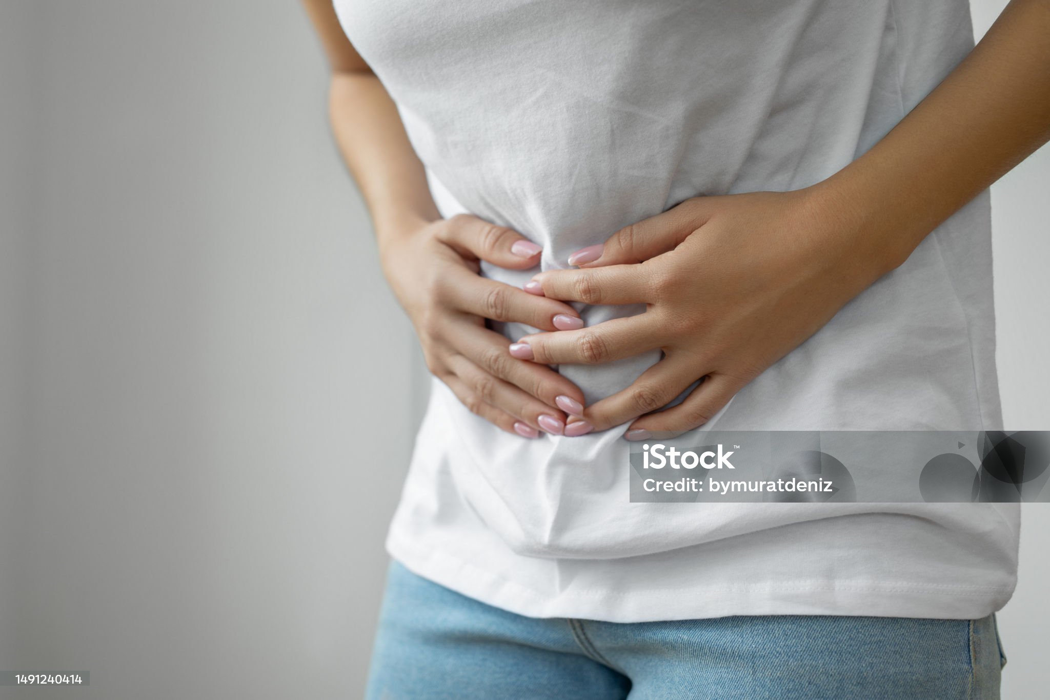 한 여성이 배를 움켜쥐고 있다.