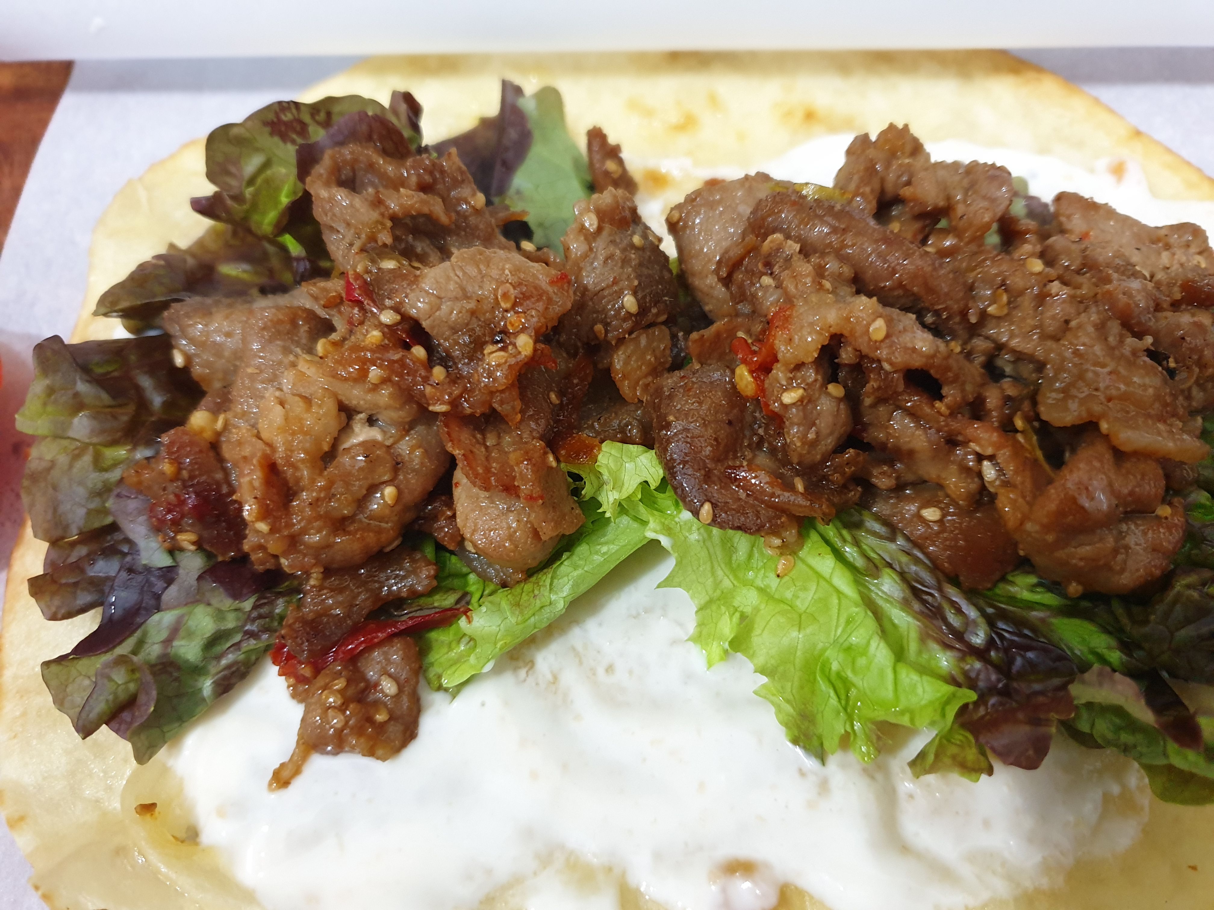 또띠아 위의 상추와 볶은 돼지고기