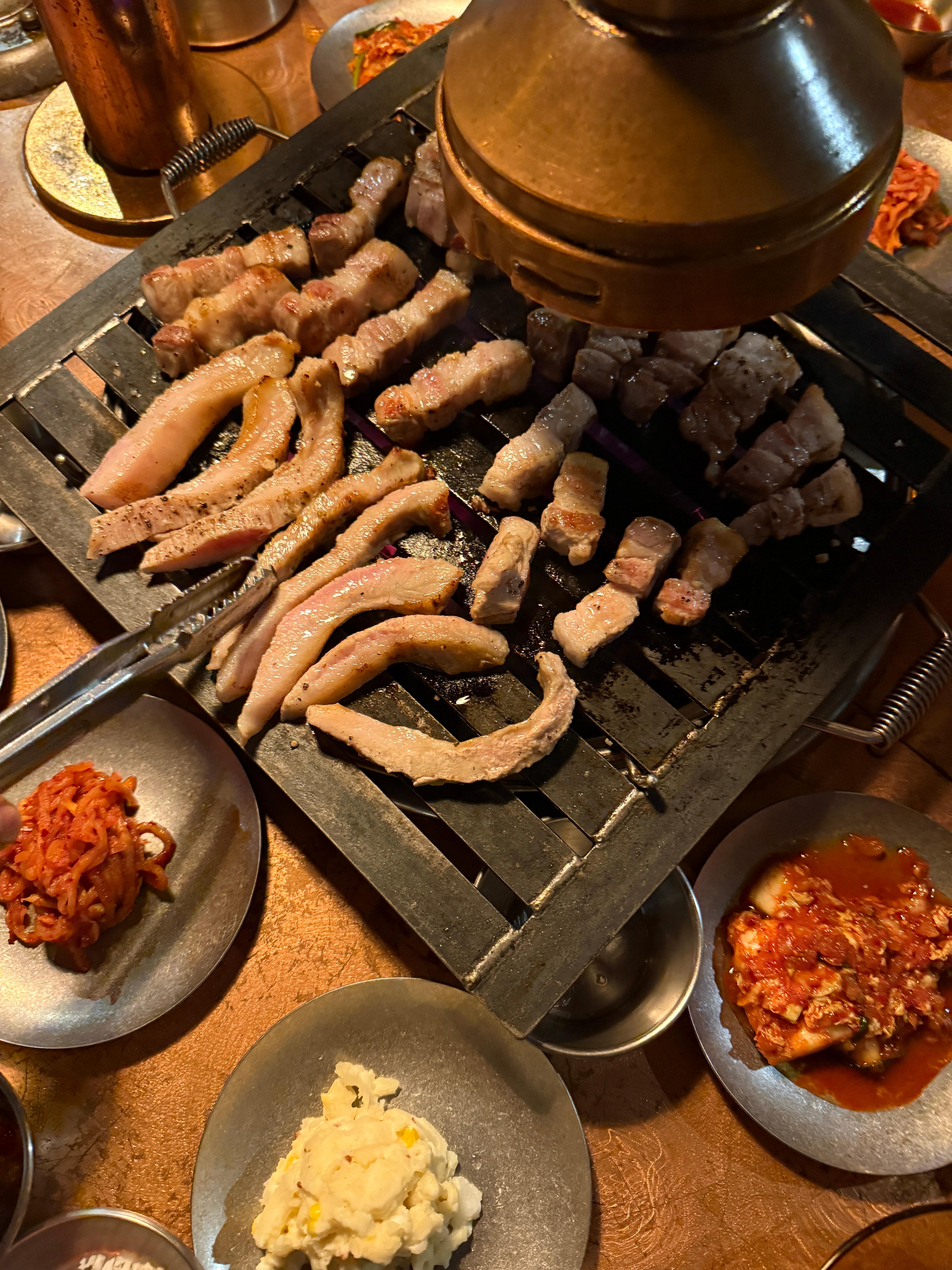 뚝도농원 불판 위에서 구워지는 삼겹살과 항정살, 육즙이 흐르는 장면