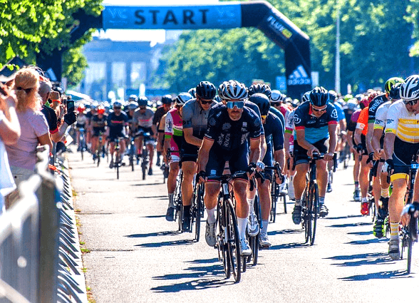 대낮에 수백명의 자전거선수들이 자전거를 타고 거리를 질주하는 풍경이다.