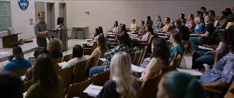 Hit Man 영화 속 대학 강의실에서 교수로 등장하는 주인공이 학생들에게 강의하는 장면