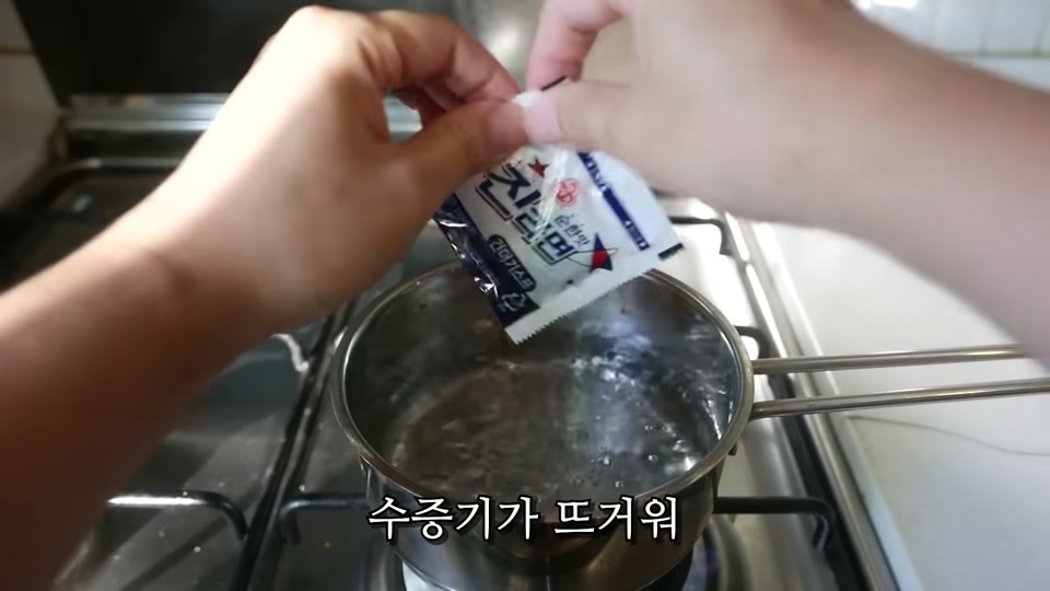 끓기 전 물에 분말스프 봉지를 넣는 장면