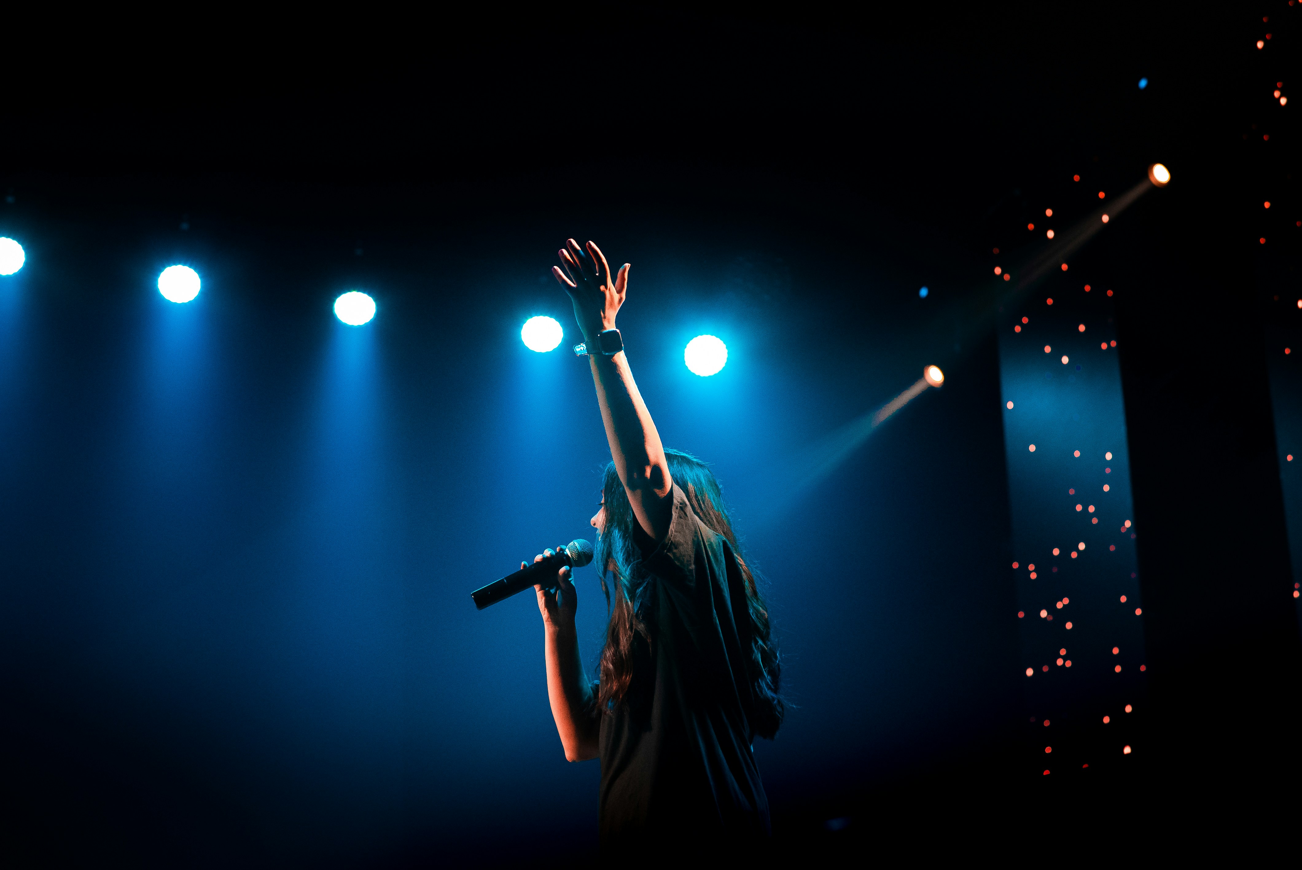 화려한 무대 조명 아래 젊은 트로트 가수가 공연하는 콘서트 장면 관련 사진