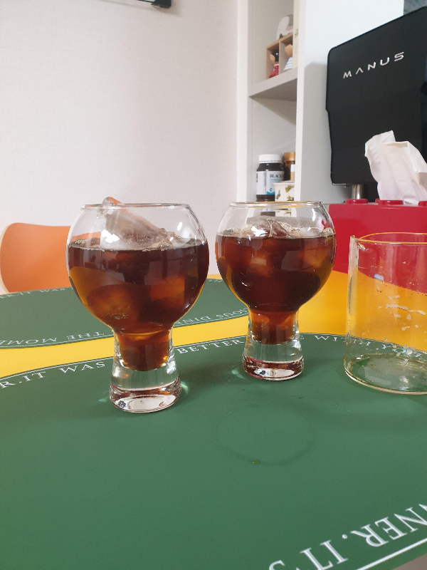 테이블 위에 아이스커피 두 잔과 빈 서버가 올려져 있다.