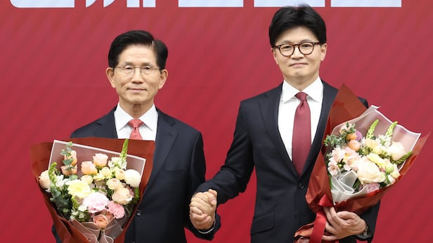 국민의힘 대선 최종 경선에 진출한 김문수(왼쪽)&middot;한동훈 후보가 29일 서울 여의도 당사에서 2차 경선 결과 발표 후 꽃다발을 들고서 기념촬영 하고 있다./국회사진기자단