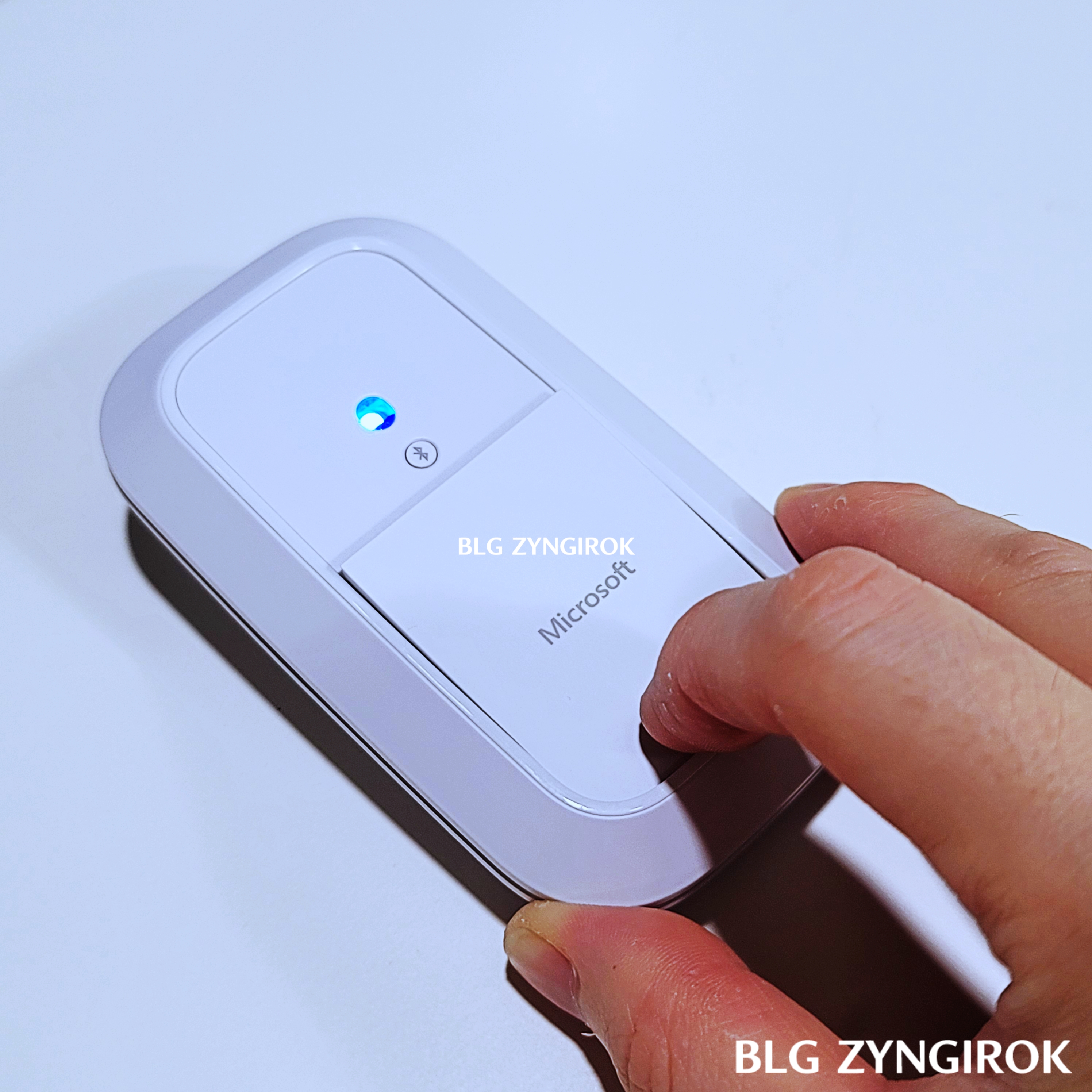 마이크로소프트 모던 디자인 마우스 하단 배터리 커버를 살짝 눌러 들어올린 모습이다.