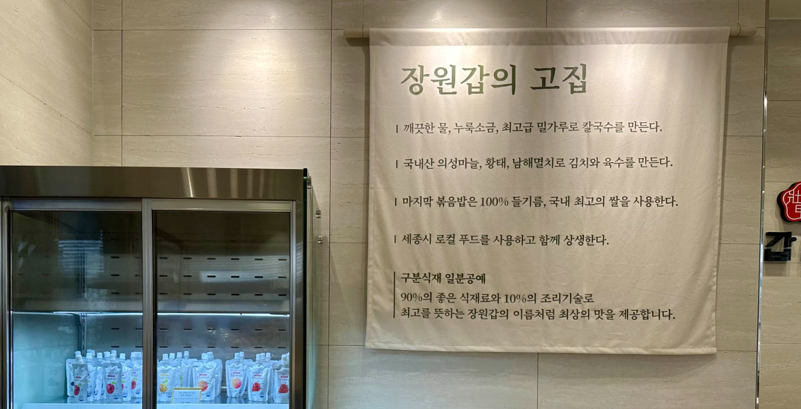 장원갑칼국수 2층 출입구에 있는 장원갑의 고집 안내판
