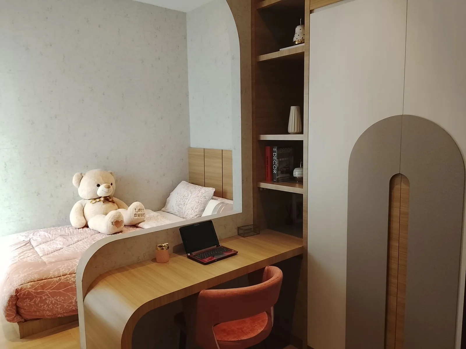 아늑한 침대, 테디베어, 컴팩트한 책상 공간을 갖춘 따뜻하고 매력적인 현대식 침실입니다.
