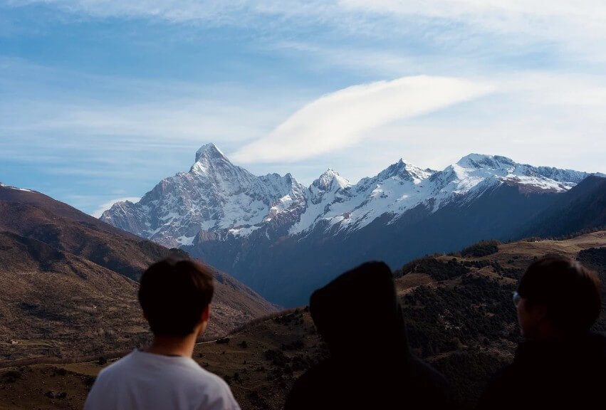 산 정상에서 하늘을 바라보는 남성