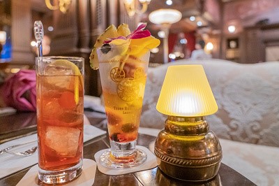 테이블 위해 칵테일 2잔이 일렬로 늘어서 있고 옆에 조그만 조명이 같이 놓여져 있다.