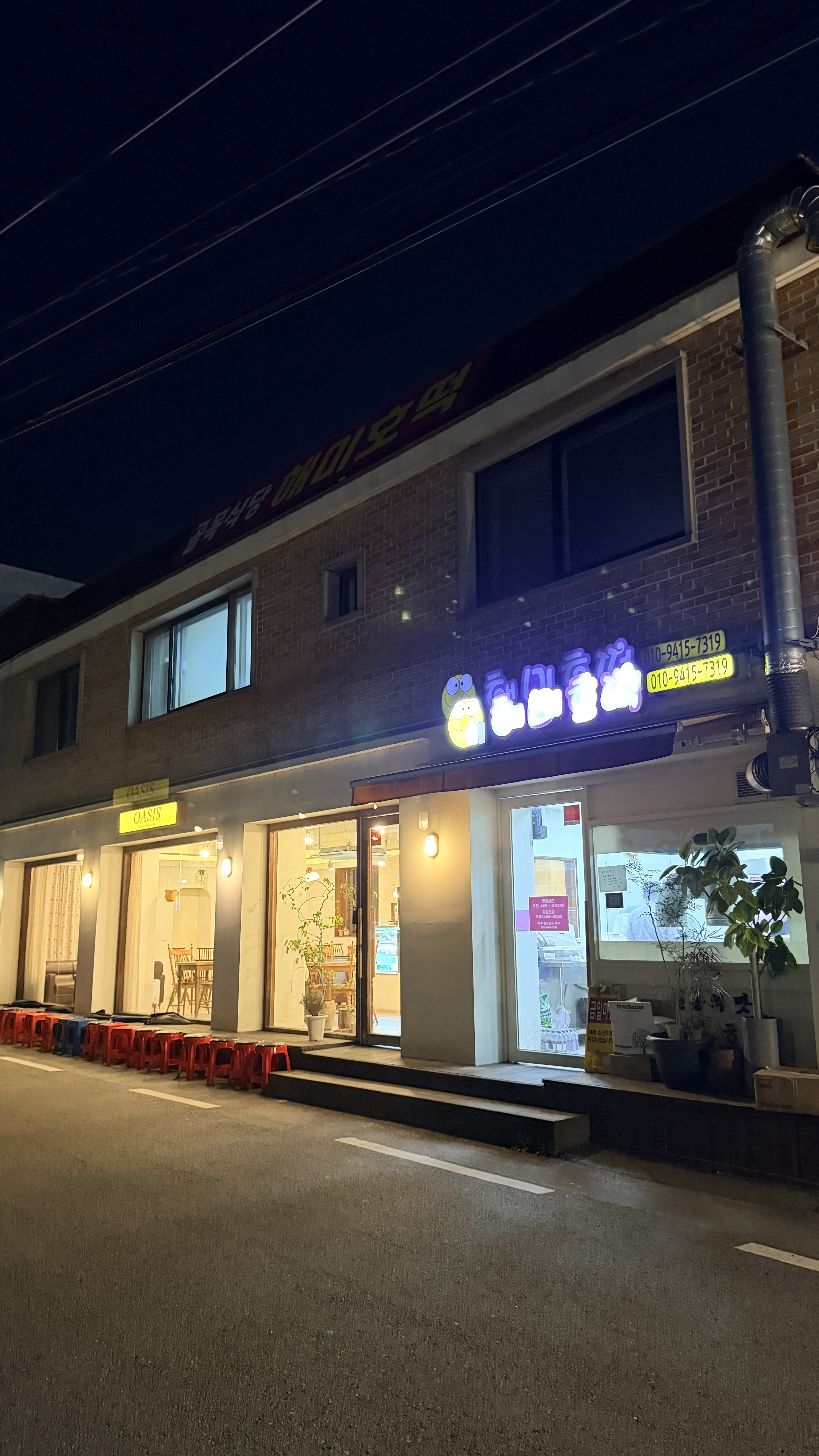 밤에 간판과 내부의 불이 켜진 해미호떡 가게 전경