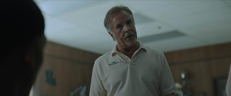 Rebel Ridge 영화 장면, 경찰 제복을 입은 남성이 대화하는 모습