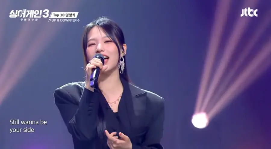 싱어게인3-
파란배경 검은 쟈켓 뒤로묶은 생머리에 긴 귀걸이를 하고 검은 마이크를 잡고 노래하는 27호