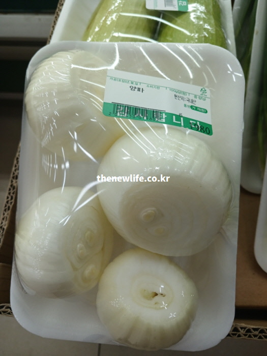요리에 바로 사용할 수 있도록 껍질을 벗겨 위생적으로 포장되어 진열된 깐 양파 마트 상품 사진