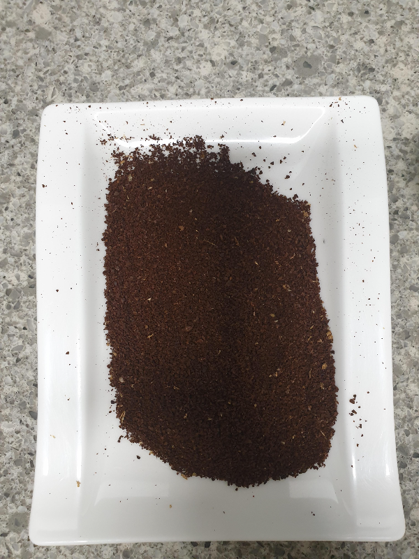 흰색 사각 접시에 분쇄된 원두가 담겨 있다.