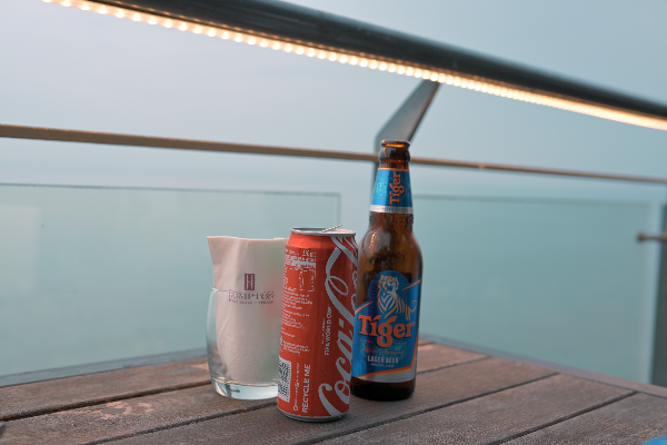 맥주병과 콜라캔이 테이블 위에 올려져 있다.
