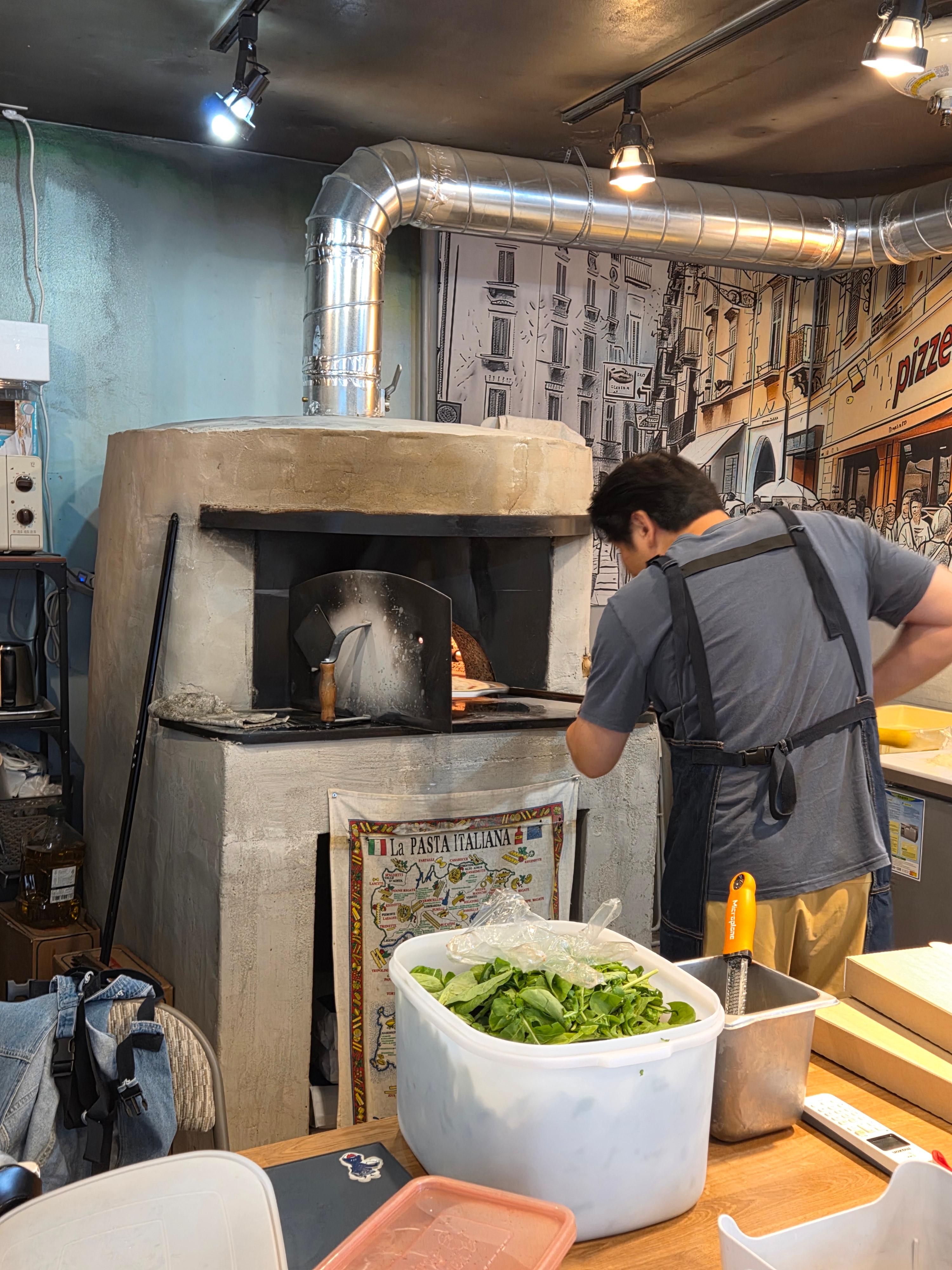매장 내부 화덕 앞에서 직원이 직접 피자를 굽는 모습