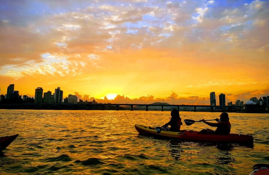 노을 풍경 속에서 카약 타는 사진