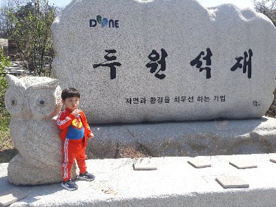 화강석 간판석 위에서 사진을 찍은 어린이