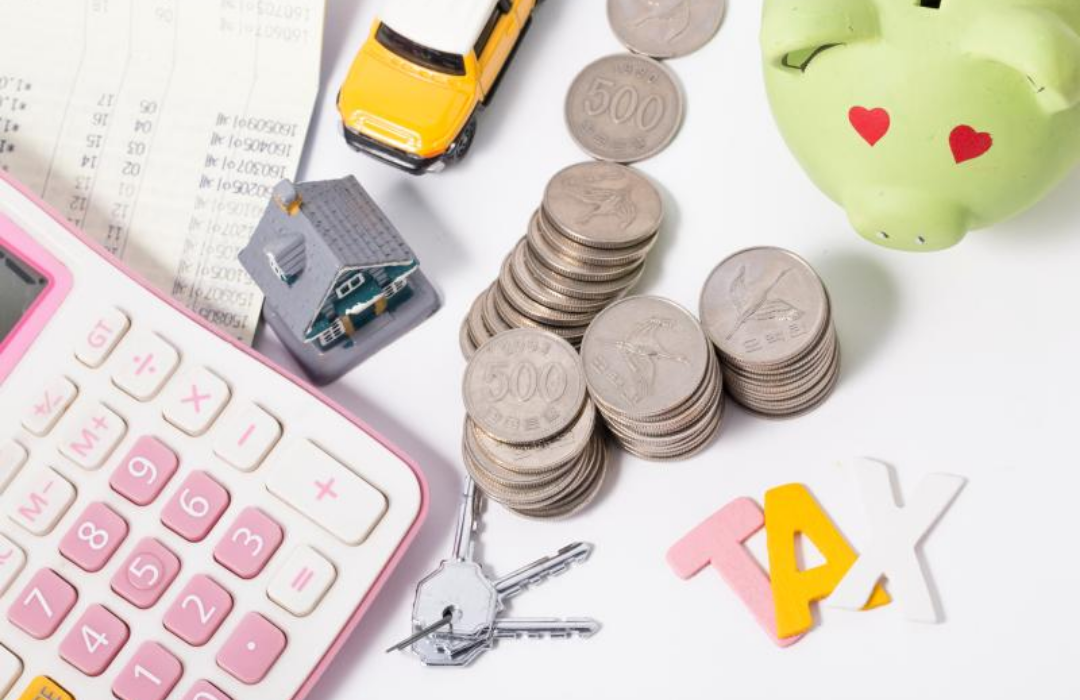 동전들과 전자계산기&amp;#44; 통장이 책상에 놓여 있다.