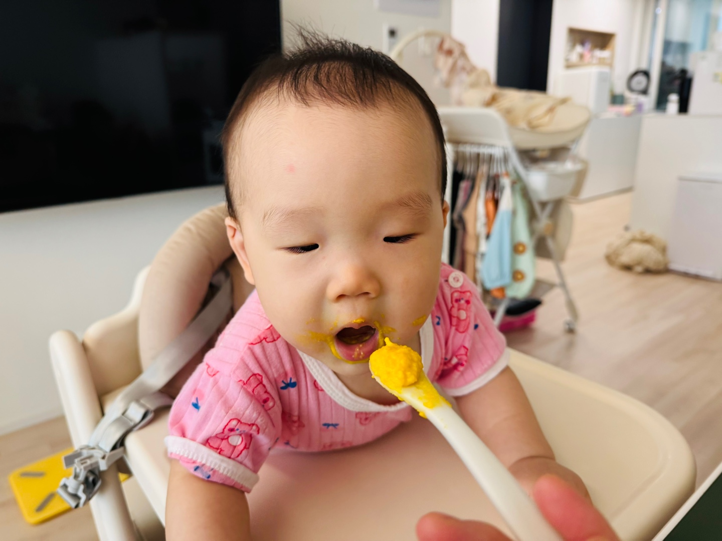 숟가락 위의 노란 매시를 바라보며 입을 벌리고 있는 찬솔이