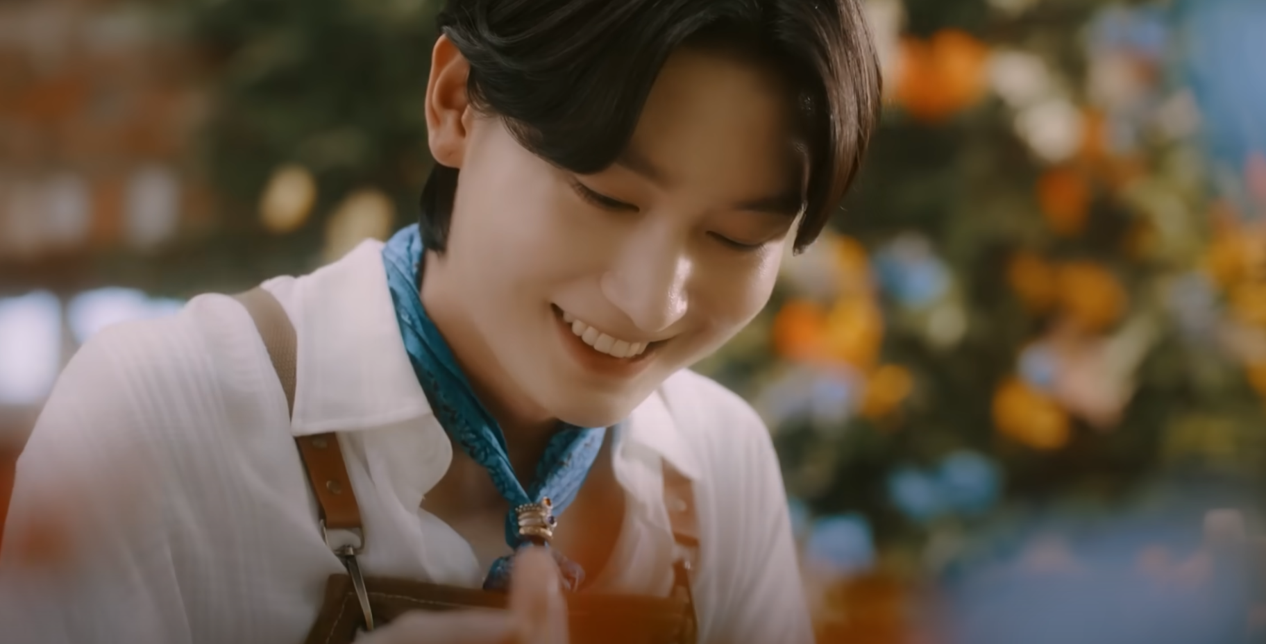 흰 셔츠를 입고 씨앗을 들고 웃는 장면