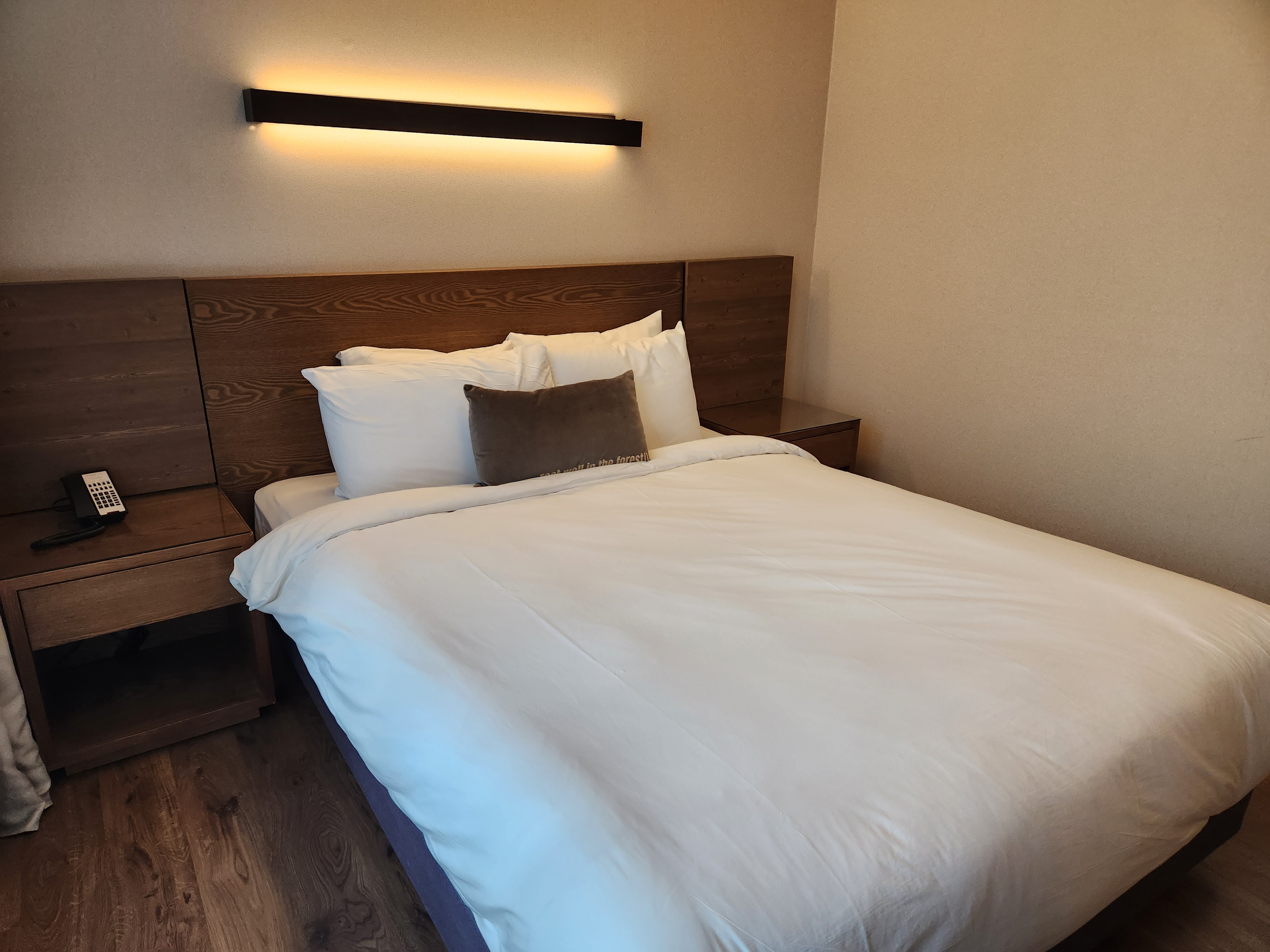 킹사이즈 침대와 은은한 벽 조명