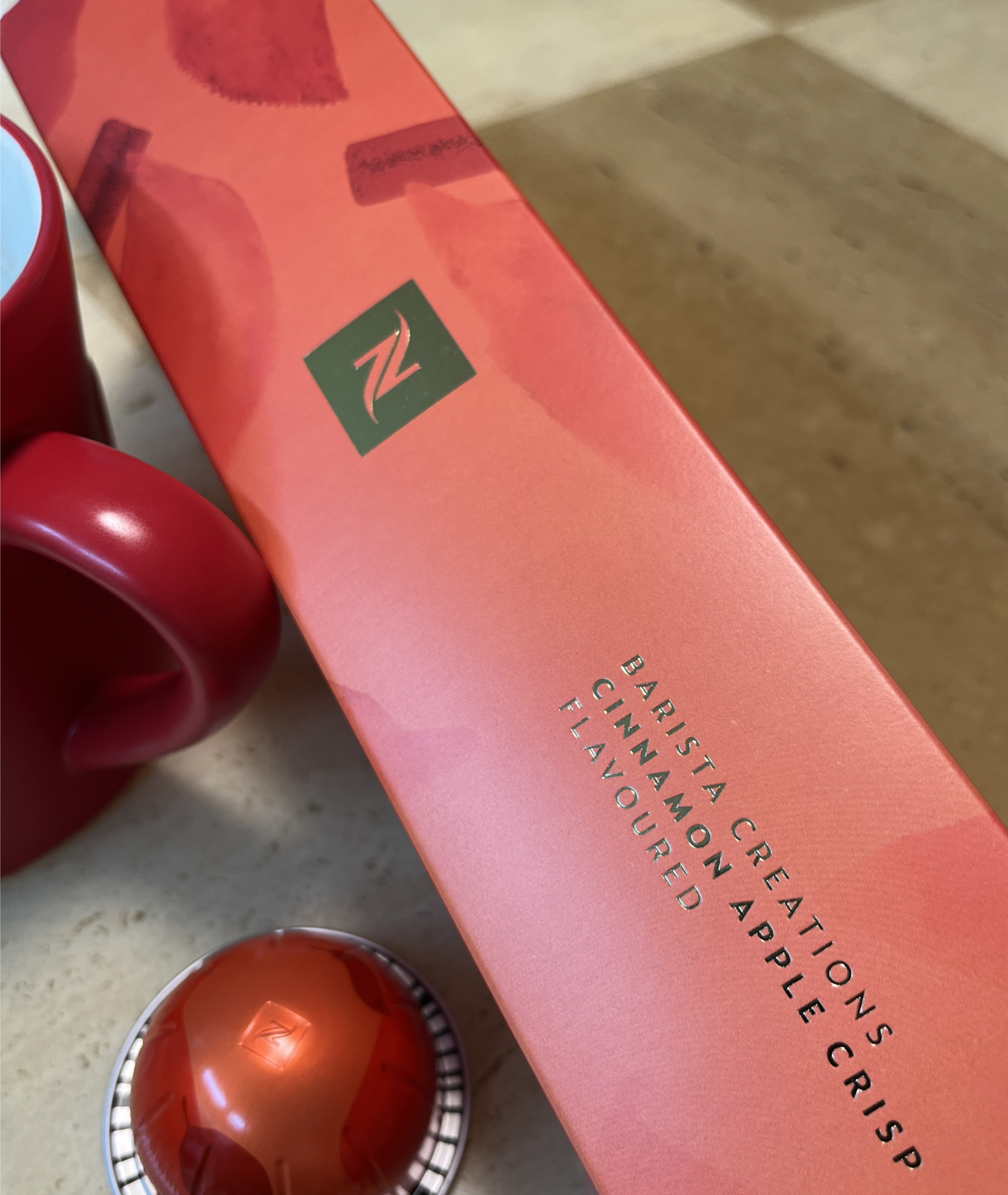 Vibrant orange and red packaging of BARISTA CREATIONS CINNAMON APPLE CRISP FLAVOURED