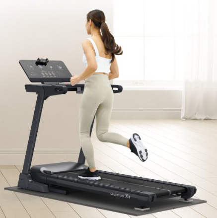 한 여성이 러닝머신에서 달리기를 하고 있는 사진