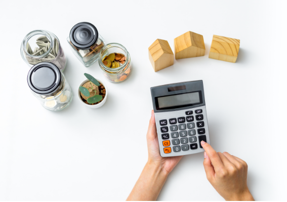 돈이 놓여있고 계산기를 두드리는 모습