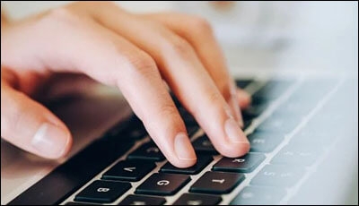 노트북 키보드에 손을 올려놓은 모습