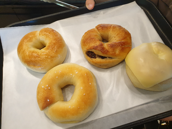 플레인, 소금, 무화과, 감자 치즈 베이글 4종이 쟁반 위에 놓여 있다.