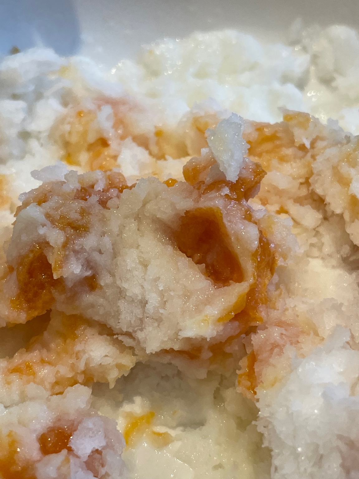 Close-up of Korean bingsu with shaved ice and chewy dried persimmon (gotgam) pieces inside.