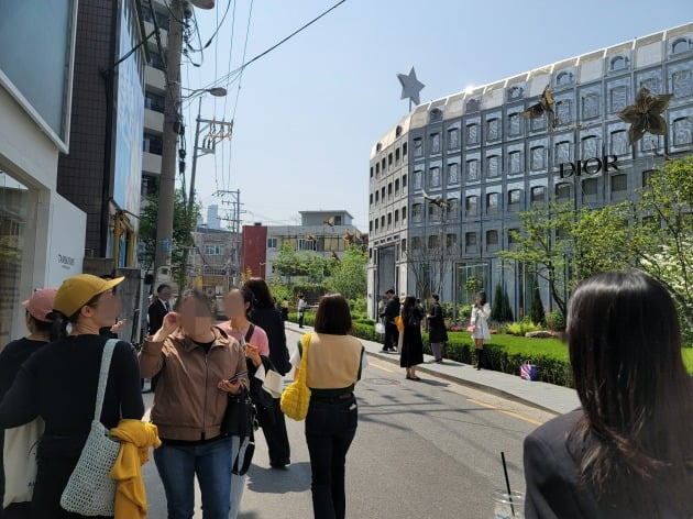 디올성수 앞에서 사람들이 인승 샷을 찍고 있다.