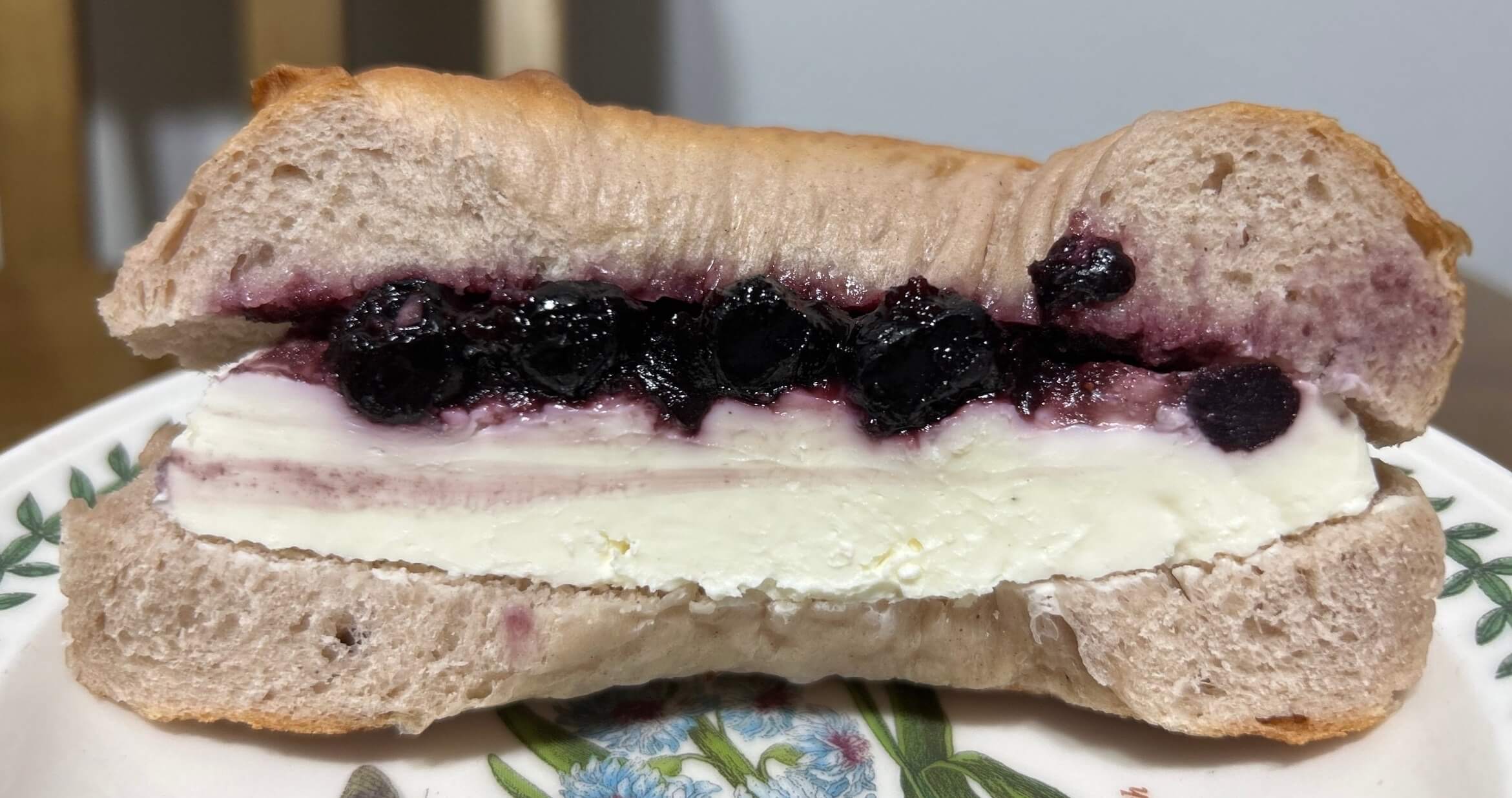 베이글 샌드 단면에 크림치즈와 블루베리가 보입니다.