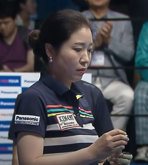 김갑선 당구선수가 당구큐대에 쵸크칠을 하고 있는 장면