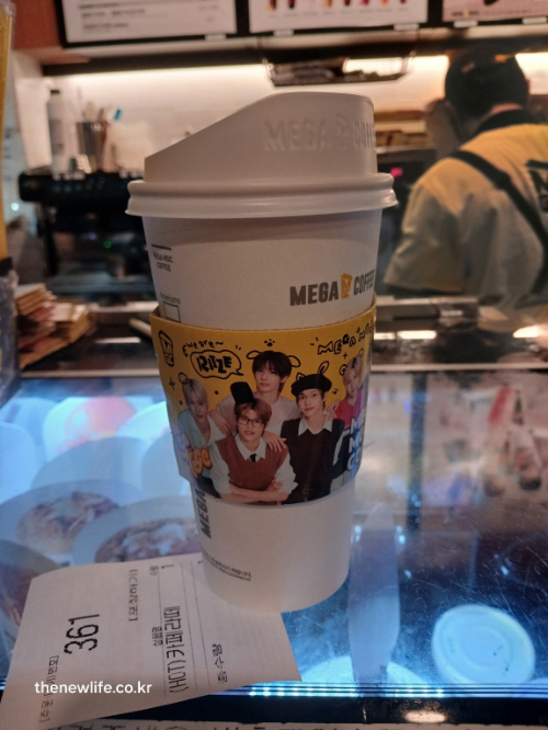 카페 카운터 위에 놓인 메가커피 테이크아웃 컵