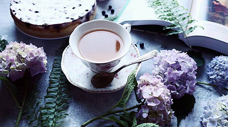 탁자위에-여러가지-꽃들과-커피가-놓여있는-모습