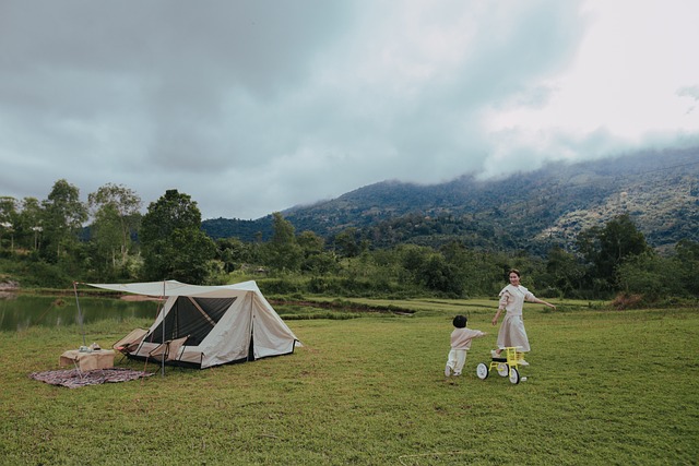 아이와 엄마가 잔디 밭에 텐트를 치고 놀고 있는 사진